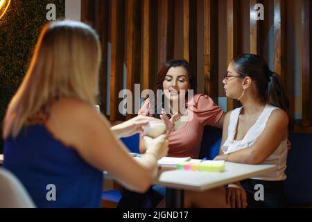 Studenten sitzen als Freunde beim Brainstorming im Café Stockfoto