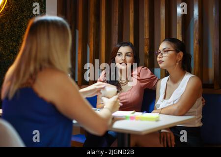 Studenten sitzen als Freunde beim Brainstorming im Café Stockfoto