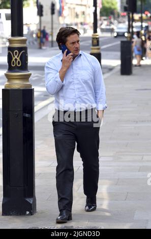 Johnny Mercer MP (Con: Plymouth Moor) - Minister für Veteranenangelegenheiten - auf seinem Mobiltelefon vor dem Kabinett in Whitehall, 11.. Juli 2022 Stockfoto