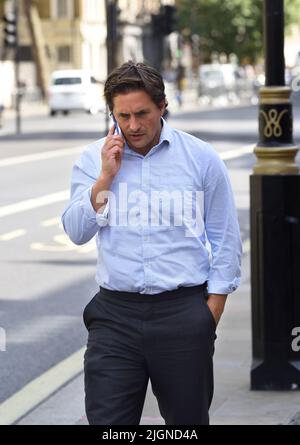 Johnny Mercer MP (Con: Plymouth Moor) - Minister für Veteranenangelegenheiten - auf seinem Mobiltelefon vor dem Kabinett in Whitehall, 11.. Juli 2022 Stockfoto