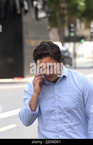 Johnny Mercer MP (Con: Plymouth Moor) - Minister für Veteranenangelegenheiten - auf seinem Handy vor dem Kabinettsbüro, vorbei an den Frauen des Ersten Weltkriegs Stockfoto