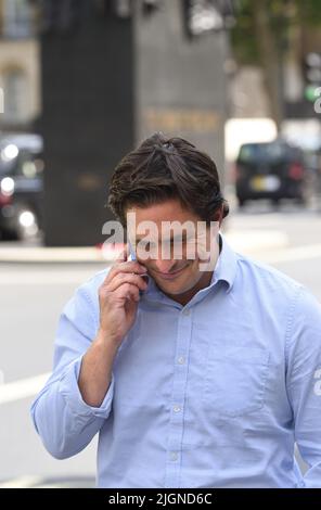 Johnny Mercer MP (Con: Plymouth Moor) - Minister für Veteranenangelegenheiten - auf seinem Mobiltelefon vor dem Kabinett in Whitehall, 11.. Juli 2022 Stockfoto