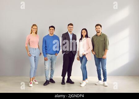 Lächelnde, multirassische Mitarbeiter posieren gemeinsam im Büro Stockfoto