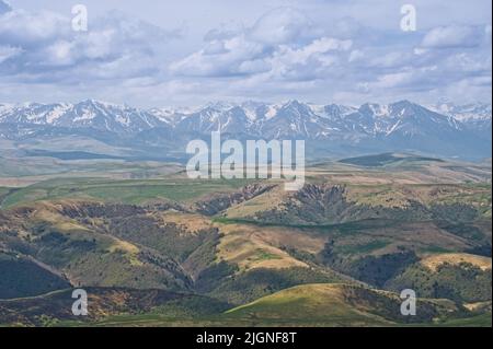 Stimmungsvolle alpine Landschaft mit Bergketten und grünen Hügeln unter dramatisch bewölktem Himmel. Wunderschöne Hochlandlandschaft. Stockfoto