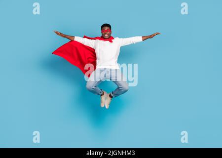 In voller Länge Porträt von aufgeregt verrückte Person heben Hände fliegen haben gute Laune auf blauem Hintergrund isoliert Stockfoto