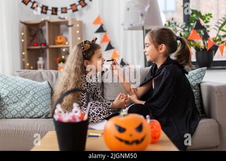 Mädchen, die zu Hause an halloween Gesichtsbemalung machen Stockfoto