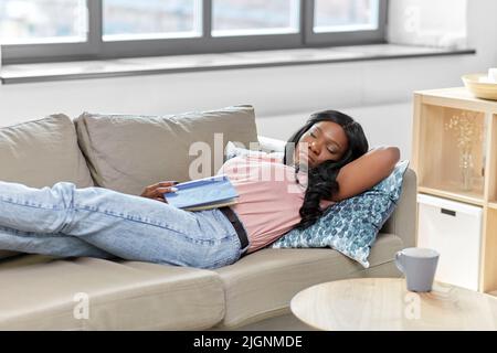 afroamerikanische Frau, die zu Hause auf dem Sofa schläft Stockfoto