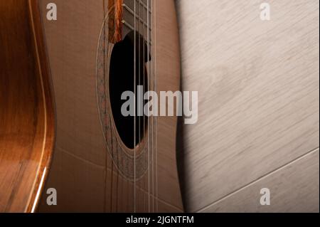 Klassische Gitarre Sound Loch und Saiten aus der Nähe auf einem hellen Holz Hintergrund Stockfoto