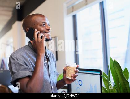 Ein schwarzer, modischer Geschäftsmann spricht auf seinem Handy mit Kaffee zum Mitnehmen Stockfoto