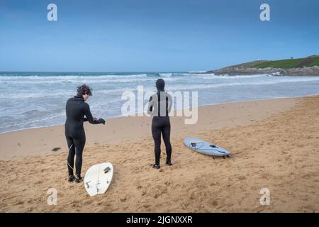 Surfer bereiten sich auf eine Surfstunde im Fistral in Newquay in Cornwall in Großbritannien vor. Stockfoto