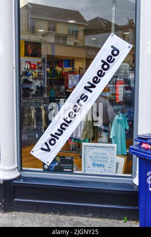 Freiwillige wollten ein Schild im Fenster eines Wohltätigkeitsladens im Zentrum von Newquay in Cornwall in Großbritannien. Stockfoto