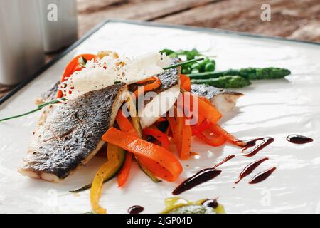 Geröstetes Pangasius-Filet auf frischem Karottenbett Stockfoto