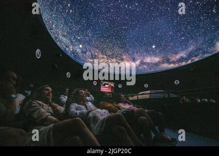 Touristen im Planetarium Ull del Montsec während der Projektion des Videos über die Nacht, die Milchstraße und Astronomie (Àger, Lleida, Spanien) Stockfoto