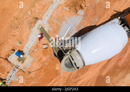 Der Prozess des Betonierens von Säulen beim Bau eines neuen Hauses mit einem Betonmischer. Stockfoto