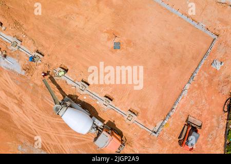 Mit Hilfe eines Betonmischers wurden Betonsäulen gegossen, um ein neues Haus zu bauen. Stockfoto