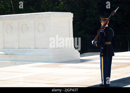 Ein Soldat steht zur Aufmerksamkeit und bewacht das Grab der unbekannten Soldaten auf dem Nationalfriedhof von Arlington in der Nähe von Washington DC Stockfoto