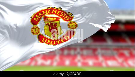 Manchester, Großbritannien, 2022. Mai: Die Flagge von Manchester United winkt mit dem Old Trafford Stadion im Hintergrund. Stockfoto