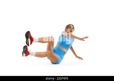 Dreisprung-Technik. Studio Aufnahme von weiblichen Athleten in Sportuniform springen isoliert auf weißem Hintergrund. Konzept von Sport, Action, Bewegung, Geschwindigkeit. Stockfoto