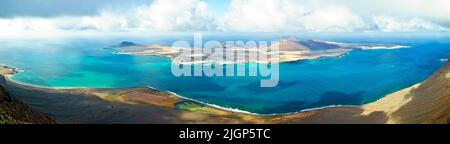 Panoramablick auf die Insel La Graciosa, das türkisfarbene Wasser von El Rio und die Salinas del Rio auf Lanzarote, Kanarische Inseln, Spanien. Stockfoto