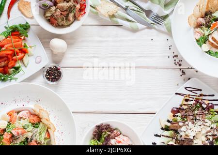 Warme Salate Rahmen auf weißem Holz flach legen Stockfoto