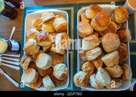 Eine Aufstrich aus Scones, gerinnter Creme, Erdbeermarmelade und Tee Stockfoto