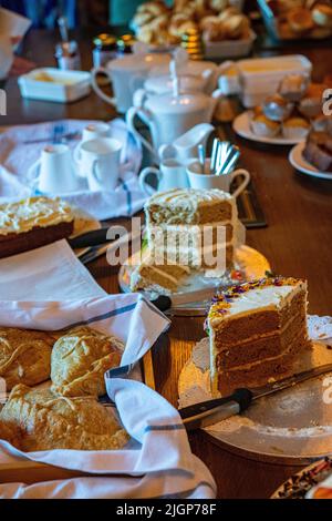 Eine Auswahl an Kuchen, Marmeladen, gerinnter Creme, Scones und Tee Stockfoto