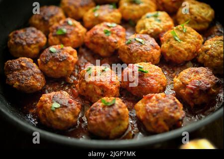 Nahaufnahme Fleischbällchen und Tomatensauce in Pfanne auf dem Tisch Stockfoto
