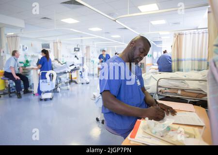 Krankenhauspersonal an einem Arbeitsplatz auf einer NHS-Station. Der NHS steht aufgrund von Personalmangel und Lohneinfrieren unter starkem Druck. Stockfoto