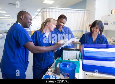 Krankenhauspersonal an einem Arbeitsplatz auf einer NHS-Station. Der NHS steht aufgrund von Personalmangel und Lohneinfrieren unter starkem Druck. Stockfoto