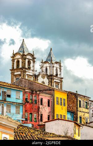 Historische barocke Kirche Turm hinter den Fassaden der alten Kolonialstil Häuser in Pelourinhoin der Stadt Salvador, Bahia Stockfoto