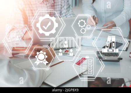 Qualitätsmanagement mit QA (Qualitätssicherung), QC (Kontrolle) und Verbesserung, Geschäftsteam diskutiert Daten mit Dokumentdaten mit VR-Bildschirm-Qualitätsmanagement Stockfoto