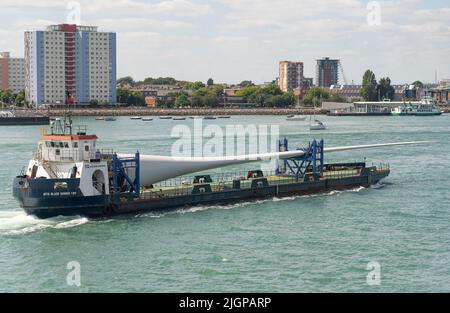 Portsmouth, Südengland, Großbritannien. 2022. Windturbinenblatt als Ladung auf Blade Runner zwei Schiffe unterwegs in Portsmouth Hafen. Hintergrund von Gosport, Stockfoto