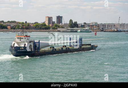 Portsmouth, Südengland, Großbritannien. 2022. Windturbinenblatt als Ladung auf Blade Runner zwei Schiffe unterwegs in Portsmouth Hafen. Hintergrund von Gosport, Stockfoto