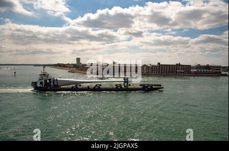 Portsmouth, Südengland, Großbritannien. 2022. Windturbinenblatt als Ladung auf Blade Runner zwei Schiffe unterwegs in Portsmouth Hafen. Hintergrund von Gosport, Stockfoto