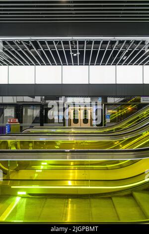 Bahnhofsebene des Bahnhofs Canary Wharf an der neuen Elizabeth Line U-Bahn in London. Rolltreppen sind in gelbes Glas gehüllt. Stockfoto