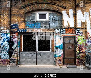 Graffiti bedeckte Wände alter Eisenbahngebäude in DER ROHEN Gelände, Revaler Straße.Friedrichshain, Berlin Stockfoto