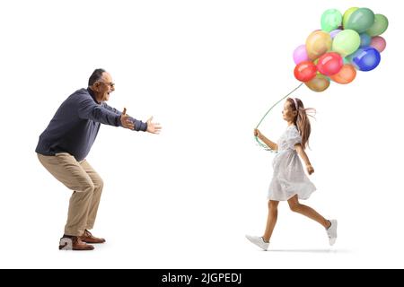 In voller Länge Profilaufnahme eines reifen Mannes, der darauf wartet, ein Mädchen mit Ballons auf weißem Hintergrund isoliert zu umarmen Stockfoto