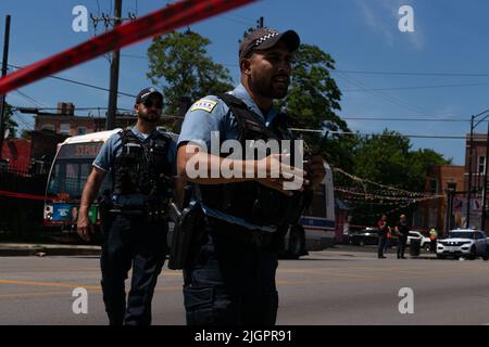 Chicago, USA. 26.. Juni 2022. Ein Polizist schreit einen Bewohner an, der versuchte, unter das Polizeiband zu gehen, um sich an einem Tatort umzudrehen, an dem am 26. Juni 2022 ein 17-jähriger Junge angeschossen und getötet wurde und ein Mann in einem Stadtbus in Chicago, IL, verletzt wurde. (Foto: Daniel Brown/Sipa USA) Quelle: SIPA USA/Alamy Live News Stockfoto