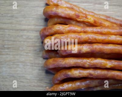 Traditionelle polnische Würste Kabanos auf einer hölzernen Oberfläche, Makrofoto. Kabanos, auch bekannt als Cabanossi oder Kabana, ist in der Regel eine lange, dünne, trockene Wurst Stockfoto