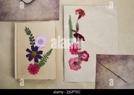 Schöne getrocknete Blumen und Notizbuch auf vintage Hintergrund Stockfoto
