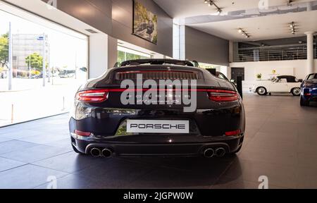 Ein Bild eines schwarzen Porsche 911 Carrera 4S Cabriolets im Autohaus. Stockfoto