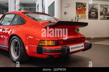 Ein Bild eines roten Porsche 911 Carrera 3,0 im Autohaus. Stockfoto