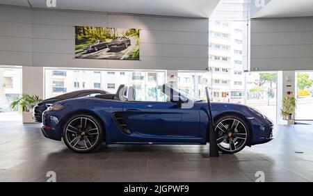 Ein Bild eines dunkelblauen Porsche 718 Boxsters in einem Autohaus. Stockfoto