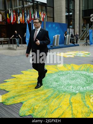 Brüssel, Belgien. 12.. Juli 2022. Der tschechische Finanzminister Zbynek Stanjura geht in den Saal des Justus-Lipsius-Gebäudes in Brüssel, Belgien, das anlässlich der tschechischen EU-Präsidentschaft am 12. Juli 2022 mit zwölf Teppichen mit Blumenmotiven von tschechischen Künstlern dekoriert wurde. Kredit: Petr Kupec/CTK Foto/Alamy Live Nachrichten Stockfoto