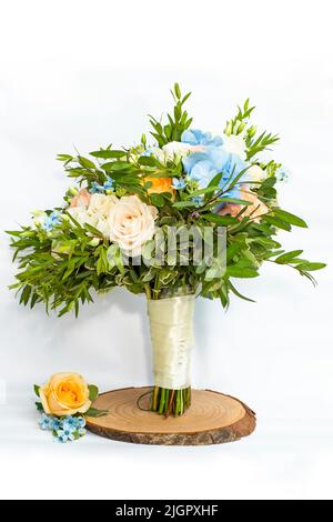 Brautstrauß und passender Boutonniere mit orangen und cremefarbenen Rosen und kleinen blauen Blüten setzen Akzente. Stockfoto