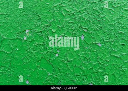 Alte grüne Farbe rissige Farbe, die auf eine alte graue Wand aufgetragen. Grunge Wandstruktur für Design. Alte Farbstruktur. Farbige Risse abstrakten Hintergrund. Stockfoto