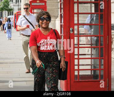 London, Großbritannien. 12.. Juli 2022. Eine Frau geht in Westminster an Whitehall entlang, trägt ein lustiges T-Shirt mit dem Slogan „Not Today Satan“ und behält ihren Sinn für Humor, während London für eine Hitzewelle mit Temperaturen über 30 Grad sorgt. Kredit: Imageplotter/Alamy Live Nachrichten Stockfoto