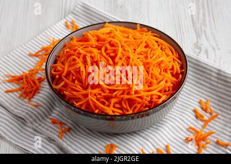 Rohe Orange Carrot schreddert in einer Schüssel, Seitenansicht. Stockfoto