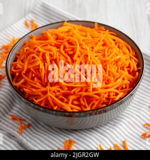 Rohe Orange Carrot schreddert in einer Schüssel, Seitenansicht. Stockfoto