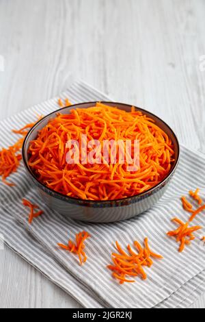 Rohe Orange Carrot schreddert in einer Schüssel, Seitenansicht. Stockfoto